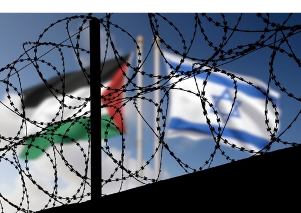 The Israel flag and the Palestine flag behind a wall with barbed wire on top of the wall representing the occupation.